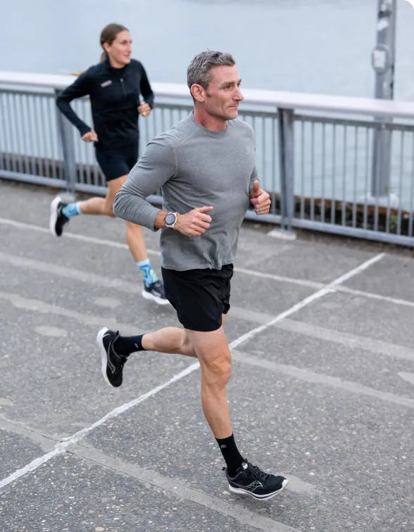 Man and woman running on pavement wearing Superfeet insoles.