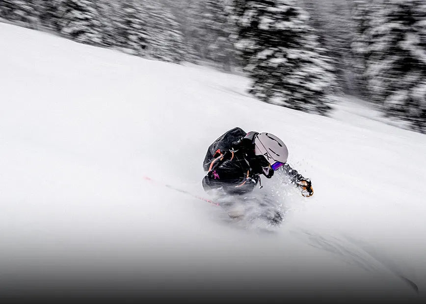 Person skiing down a mountain while wearing Superfeet Winter insoles.